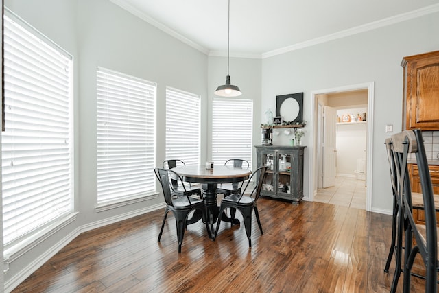 dining space featuring dark wood-type flooring and ornamental molding