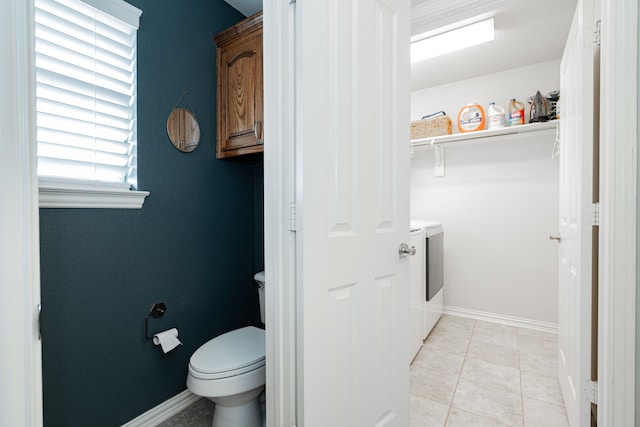 bathroom with toilet, separate washer and dryer, and tile patterned floors