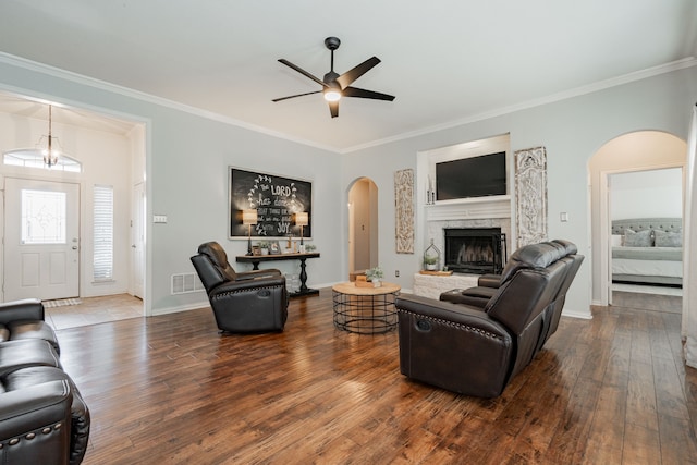 living room featuring ceiling fan, a high end fireplace, crown molding, and dark hardwood / wood-style floors