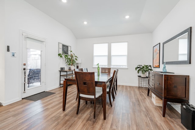 dining room featuring lofted ceiling, a wealth of natural light, and light hardwood / wood-style flooring