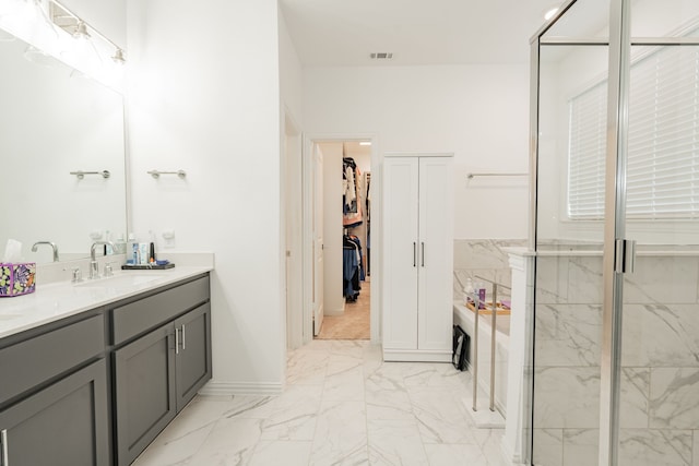 bathroom with vanity and shower with separate bathtub