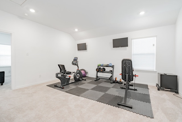 workout room featuring vaulted ceiling and carpet flooring