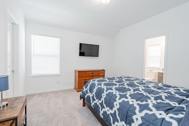 carpeted bedroom with lofted ceiling and connected bathroom