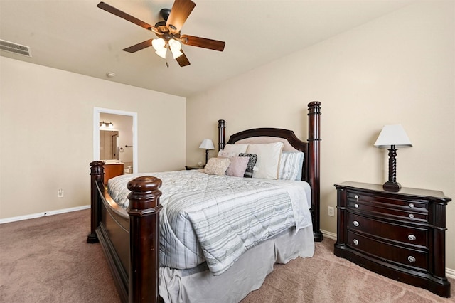 carpeted bedroom with ensuite bathroom and ceiling fan