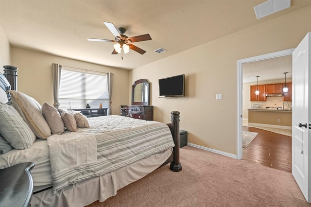 carpeted bedroom featuring ceiling fan and sink