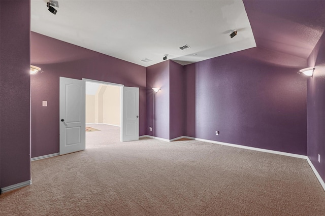 spare room with light carpet and vaulted ceiling