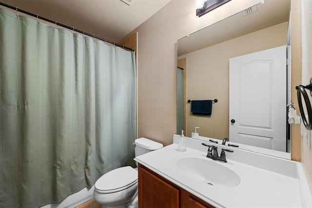 bathroom featuring a textured ceiling, toilet, vanity, and a shower with curtain