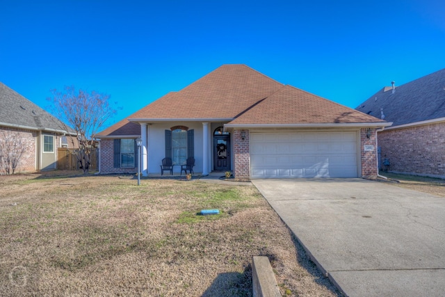 view of front of home with a front yard, covered porch, and a garage