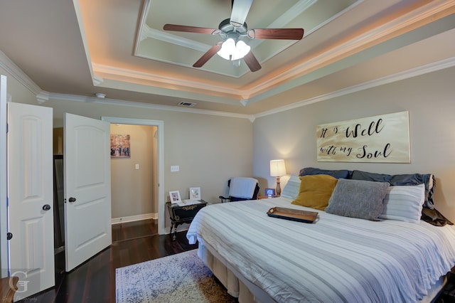 bedroom with ceiling fan, dark hardwood / wood-style flooring, crown molding, and a tray ceiling