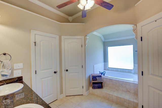 bathroom with tile patterned floors, vanity, ceiling fan, ornamental molding, and tiled bath