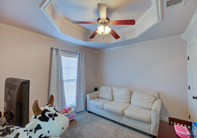 carpeted living room featuring ceiling fan, crown molding, and a tray ceiling