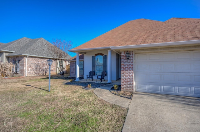 view of front of home with a garage, a front yard, and a porch