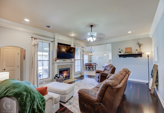 living room featuring ceiling fan, ornamental molding, and wood-type flooring