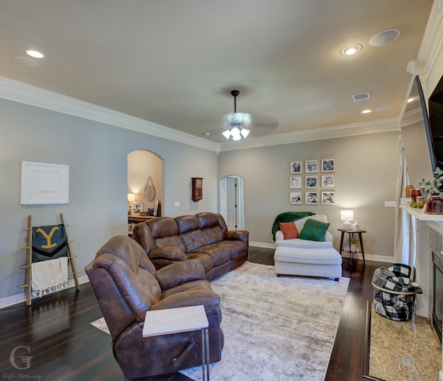 living room with ceiling fan, crown molding, a fireplace, and dark hardwood / wood-style floors