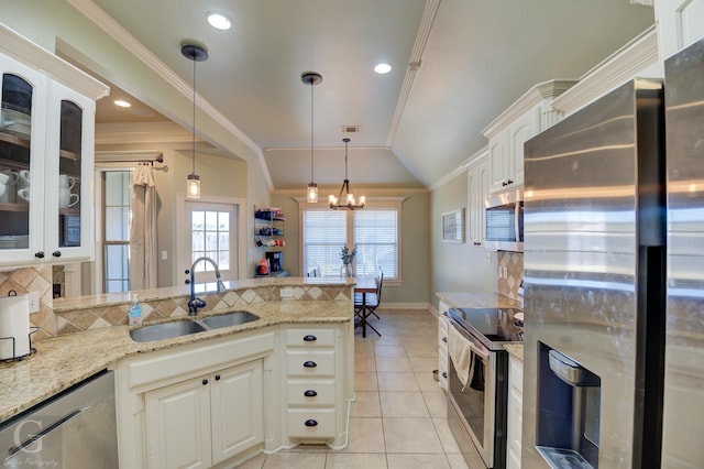 kitchen featuring white cabinets, stainless steel appliances, tasteful backsplash, sink, and vaulted ceiling