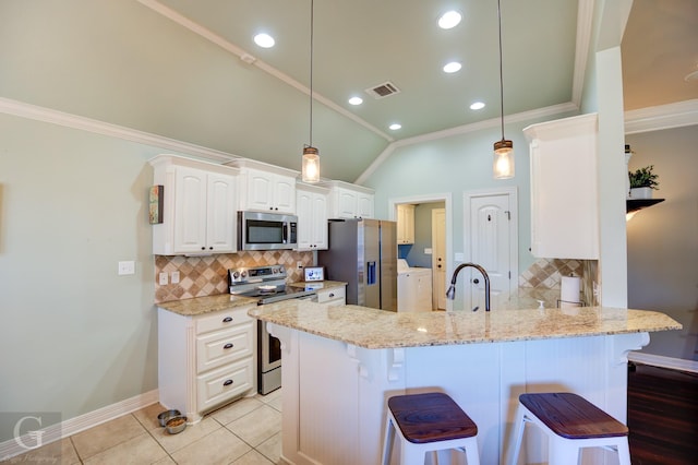 kitchen featuring a kitchen breakfast bar, kitchen peninsula, stainless steel appliances, and vaulted ceiling