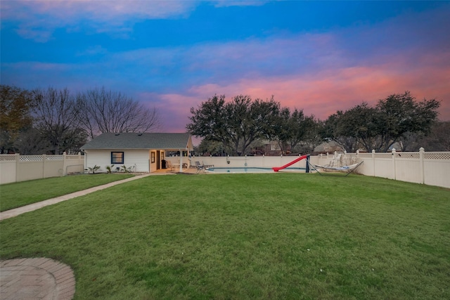 yard at dusk with a fenced in pool and a patio