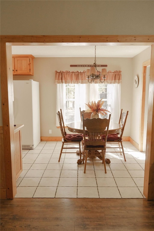 dining area with light hardwood / wood-style flooring and an inviting chandelier