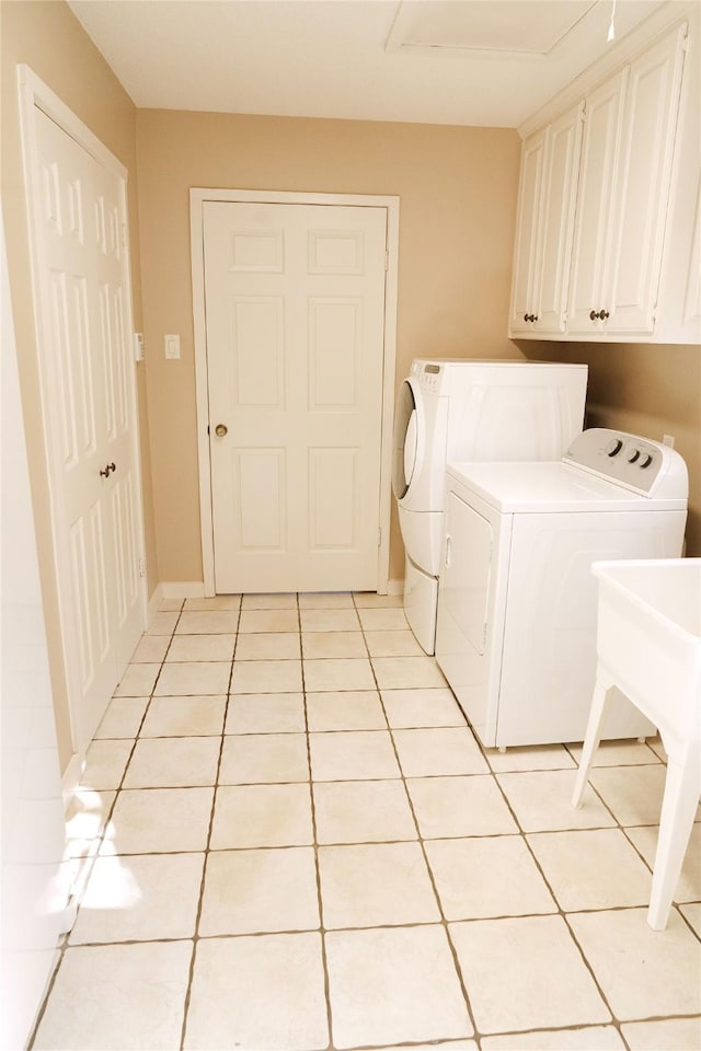 washroom featuring cabinets, separate washer and dryer, and light tile patterned flooring