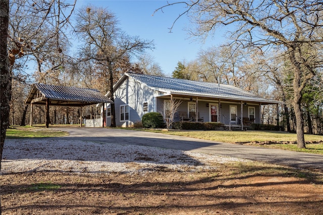 view of front of property featuring covered porch, a front yard, and a carport