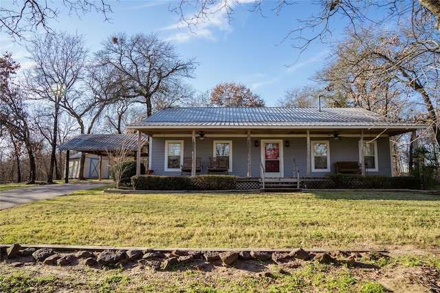 view of front facade with ceiling fan, an outdoor structure, a front lawn, and a porch