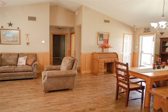 living room featuring vaulted ceiling, a chandelier, and hardwood / wood-style flooring