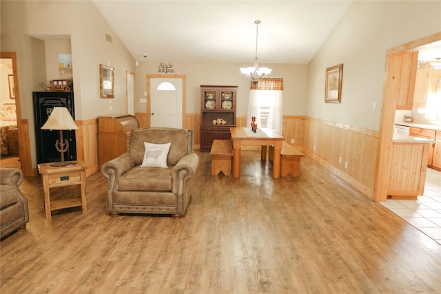 interior space with light wood-type flooring, vaulted ceiling, and a chandelier