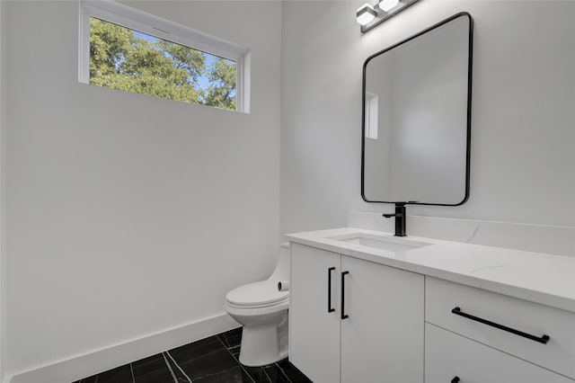 bathroom with toilet, tile patterned floors, and vanity