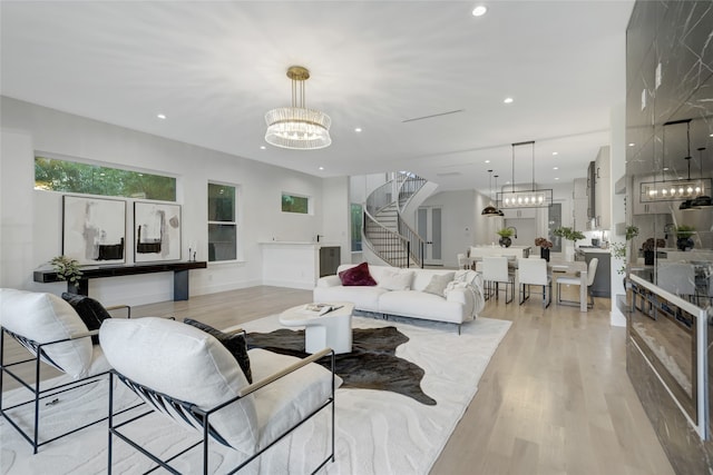 living room with light hardwood / wood-style floors and a notable chandelier