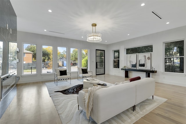 living room with light wood-type flooring and a notable chandelier