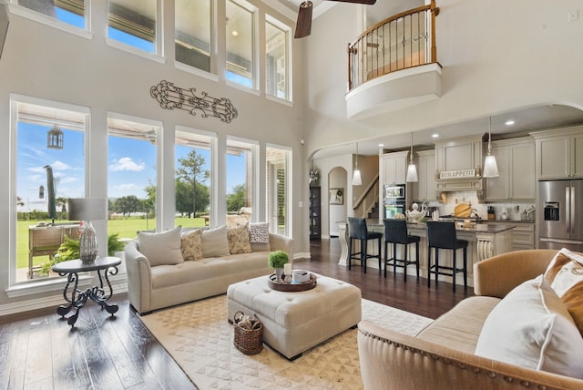 1901 Yucatan Dr, Granbury, TX 76048 - living room with a high ceiling, plenty of natural light, hardwood / wood-style flooring, arched walkways, and stairway