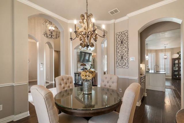 dining space with dark hardwood / wood-style flooring, ornamental molding, and a chandelier