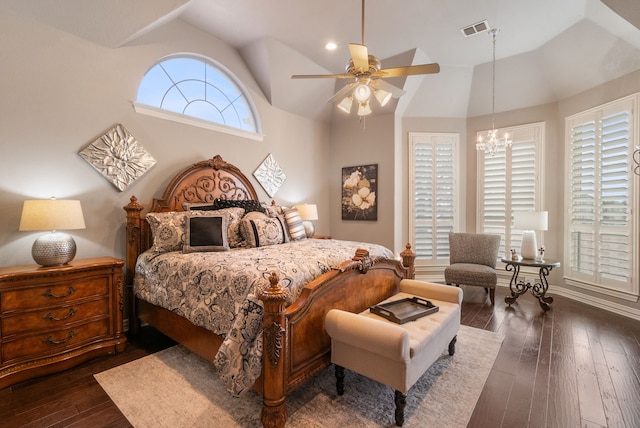 bedroom featuring lofted ceiling, dark wood-type flooring, and ceiling fan with notable chandelier