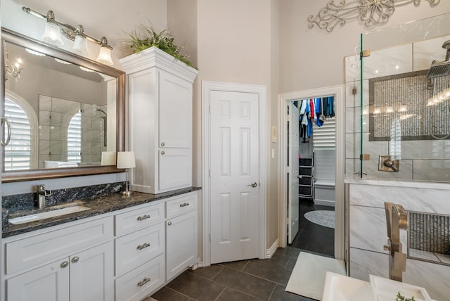 bathroom with a high ceiling, tile patterned floors, a shower with door, and vanity