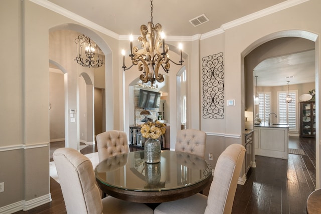 1901 Yucatan Dr, Granbury, TX 76048 - dining area with arched walkways, a chandelier, dark wood finished floors, ornamental molding, and baseboards