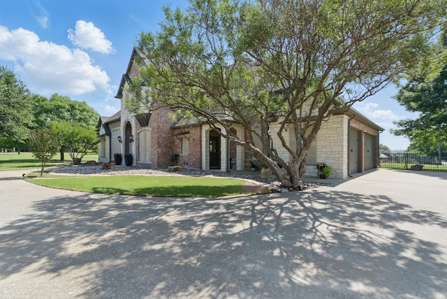 1901 Yucatan Dr, Granbury, TX 76048 - view of front of home featuring driveway, stone siding, brick siding, and a garage