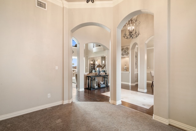 carpeted foyer with a high ceiling and crown molding