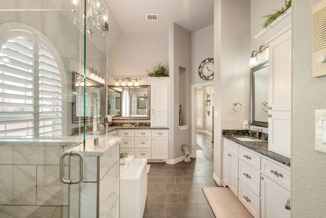 1901 Yucatan Dr, Granbury, TX 76048 - bathroom featuring two vanities, tile patterned flooring, a stall shower, and high vaulted ceiling