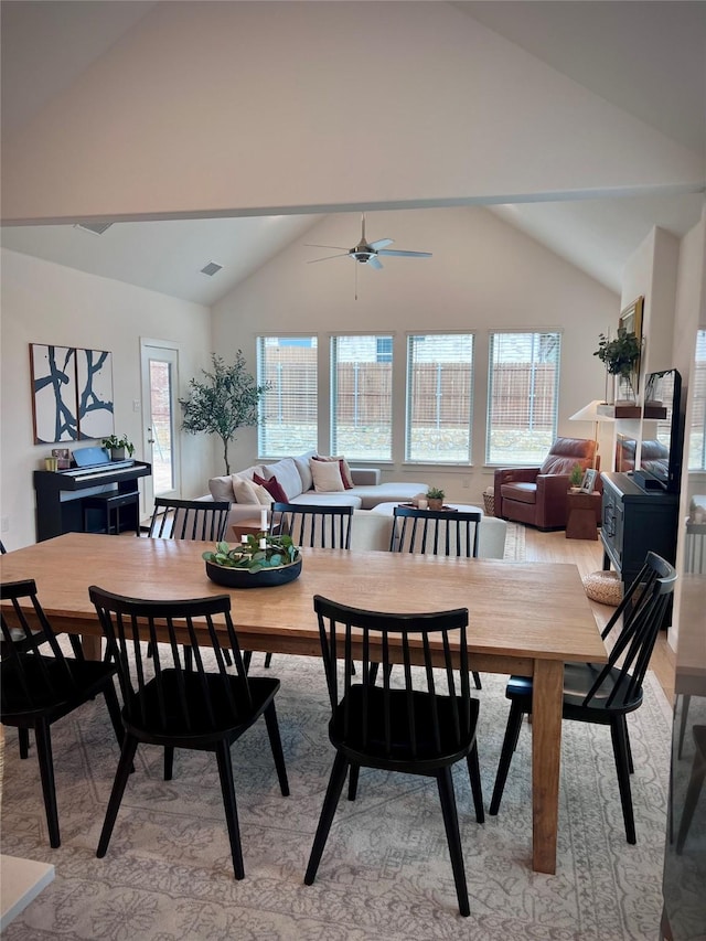 dining space with ceiling fan, lofted ceiling, and light hardwood / wood-style floors