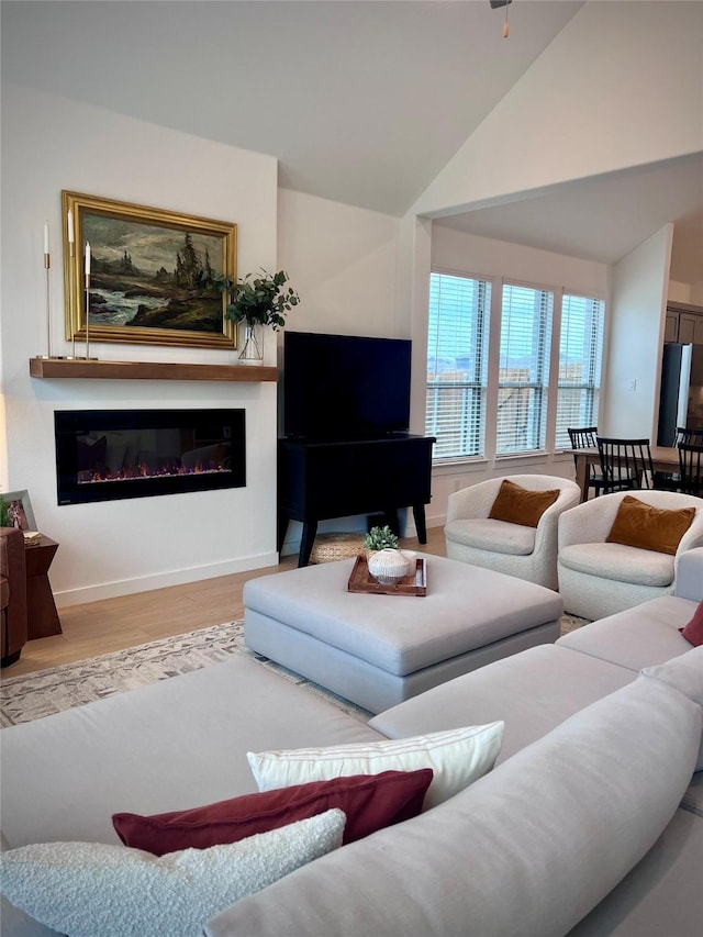 living room featuring vaulted ceiling and light hardwood / wood-style flooring