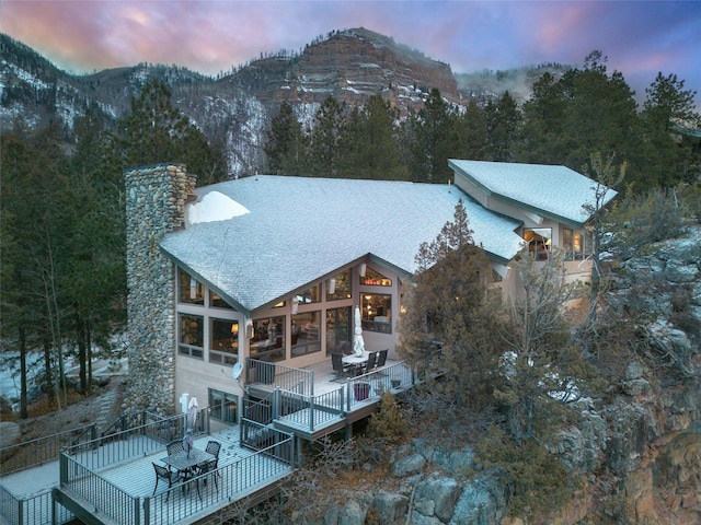 back house at dusk featuring a deck with mountain view