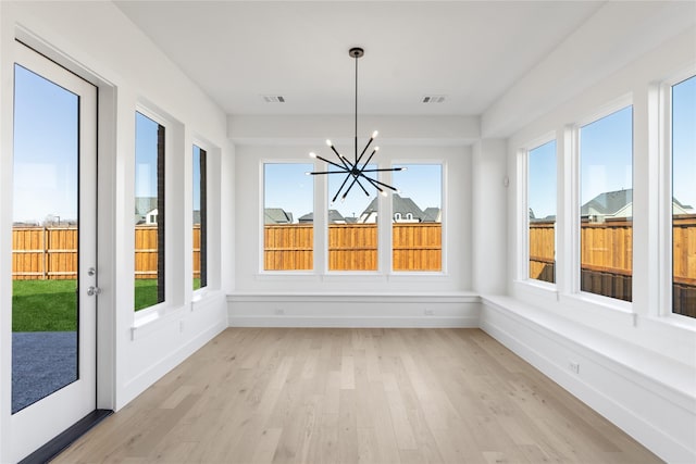 unfurnished sunroom featuring visible vents and a notable chandelier