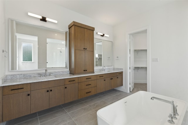 full bath featuring double vanity, a freestanding tub, and a sink