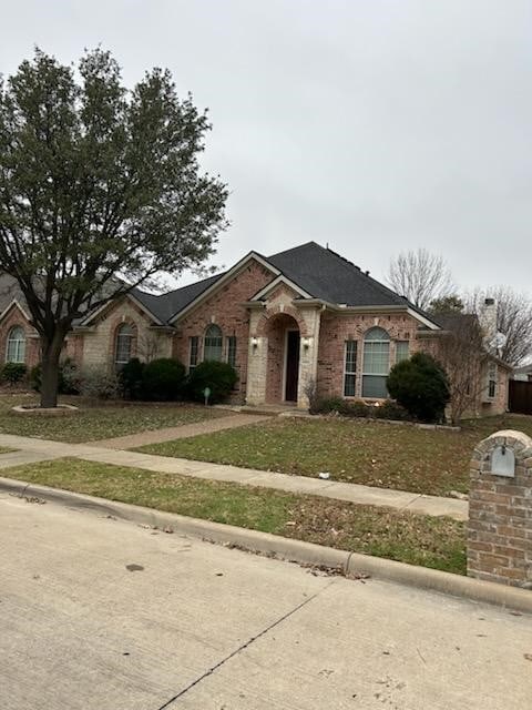 single story home with a front lawn