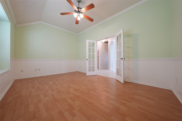 spare room featuring lofted ceiling, crown molding, light hardwood / wood-style flooring, and french doors