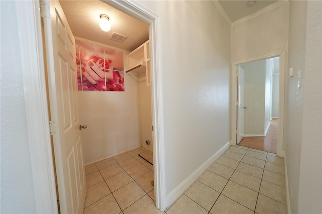 corridor featuring light tile patterned flooring and crown molding