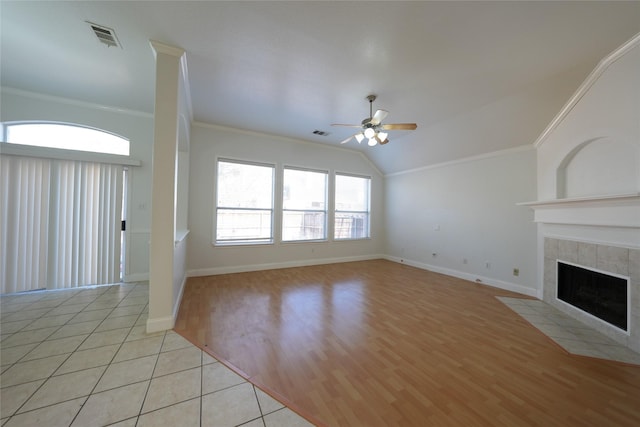 unfurnished living room with crown molding, ceiling fan, a tile fireplace, and light wood-type flooring