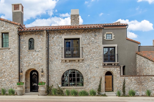 mediterranean / spanish house featuring a balcony