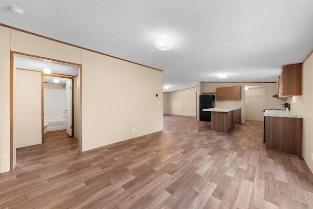 unfurnished living room with crown molding, wood-type flooring, and sink