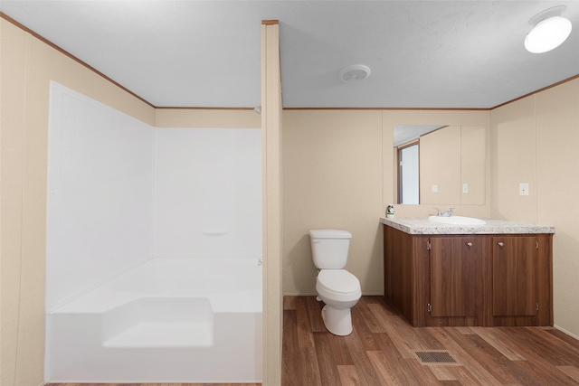 bathroom with toilet, hardwood / wood-style floors, and vanity